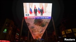 Ogromni ekran u Pekingu na kojem se prikazuje susret predsjednika Kine i Rusije, Si Đinpinga i Vladimira Putina tokom sastanka na marginama samita Šangajske organizacije za saradnju (SCO) u Uzbekistanu, 16. septembar 2022. 