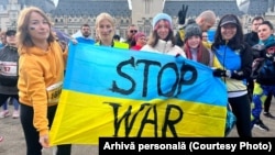 Iryna Horoshayeva (left) helps hold up an anti-war banner at a demonstration in Iasi, Romania. 