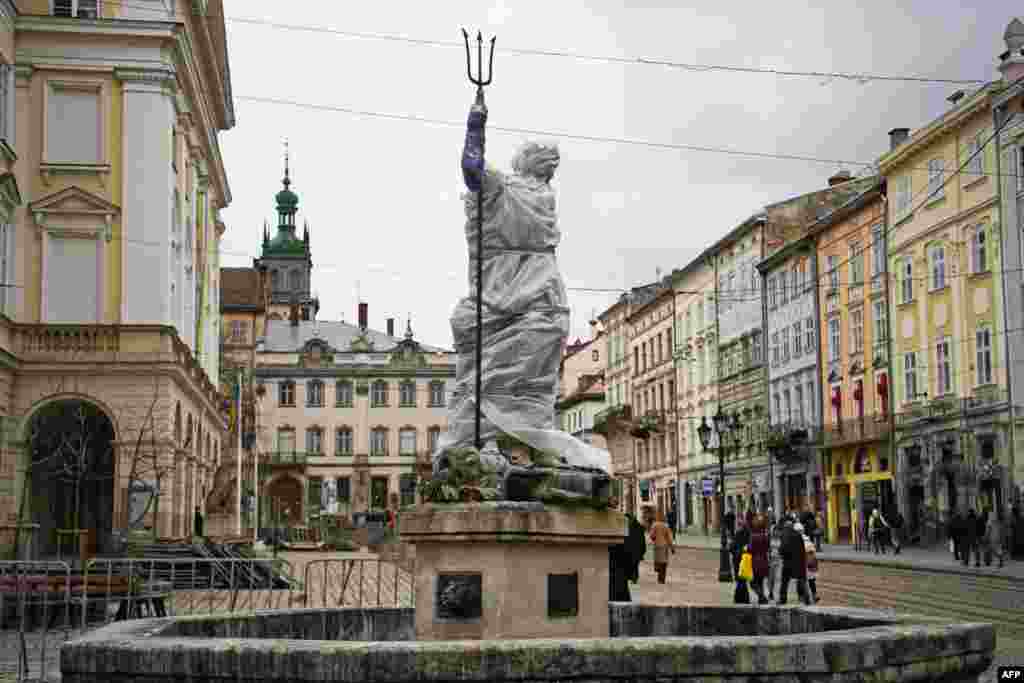 A wrapped statue of Neptune in the center of Lviv. &nbsp; In recent days, Lviv locals have been wrapping art treasures in the historic town center in an attempt to protect them from missile strikes, which many fear will be launched against the famously elegant city. &nbsp;