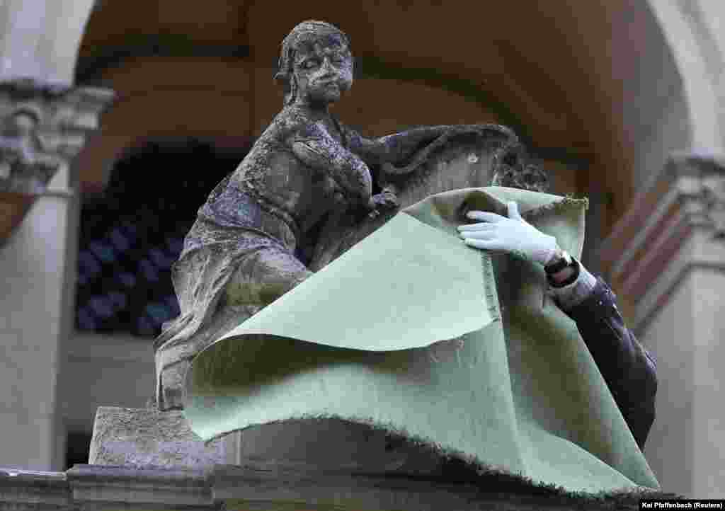 Volunteers wrap statues outside Lviv&rsquo;s St. George&#39;s Cathedral. &nbsp; Construction companies have loaned their scaffolding equipment free of charge to volunteers involved in the protection efforts, but according to Andriy Salyuk, who heads the Lviv branch of Ukraine&rsquo;s Society for the Protection of Monuments, materials such as metal sheeting are now in short supply.&nbsp; &nbsp; &nbsp;