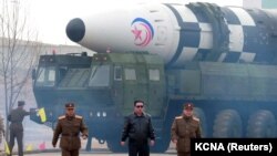 Sjevernokorejski lider Kim Džong Un pored onoga što su državni mediji nazvali "novim tipom interkontinentalnih balističkih raketa". Nije utvrđen datum nastanka fotografije, a objavljena je 24. marta 2022. godine.