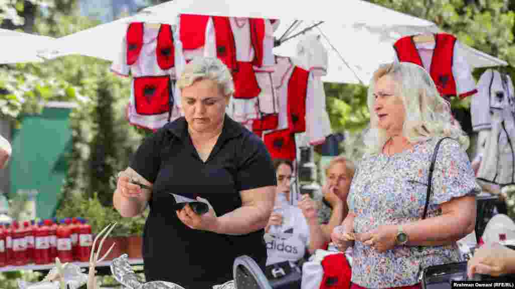 Afërdita Selimi-Jonuzi (majtas) nga Podujeva ishte njëra nga pjesëmarrëset që shiste ushqime tradicionale. Ajo tha se puna i shtohet dukshëm gjatë verës. “Mërgimtarët porosisin më së shumti fli dhe pite me kungull”, deklaroi ajo.