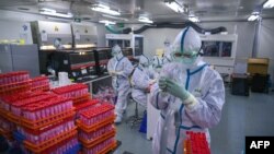 Kineski laboranti obrađuju testove na korona virus u laboratoriji u Tjenđinu, novembar 2020.