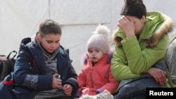 A woman sits with children as evacuees, including civilians who left the area near Azovstal steel plant in Mariupol, arrive at a temporary accommodation center in the Donetsk region in May.