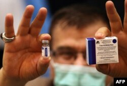 Iráni egészségügyi dolgozó mutatja a Szputnyik-vakcinát a teheráni Khomeini kórházban, 2021. február 9-én