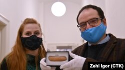 Археолозите Алена Сламова и Иржи Махачек показват костта в Бърно на 11 февруари