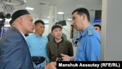 Косай Маханбаев (слева) с другими пострадавшими во время Кантара разговаривает с работником прокуратуры. Алматы, 6 мая 2022 года