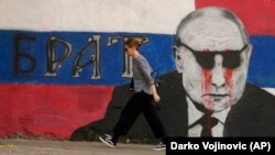 Žena prolazi pored murala na zgradi u Beogradu na kojem je prikazan ruski predsednik Vladimir Putin i na kojem piše “brat”. Beograd, 7. maj 2022.