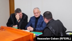 Ex-președintele Igor Dodon și avocații săi discutând în timpul ședinței de judecată în dosarul Energocom, 23 decembrie 2022.