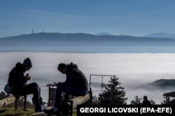 Njerëzit duke shijuar një ditë me diell në malin afër fshatit Kuçkovë, ndërsa mjegulla dhe ndotja kanë mbuluar Shkupin, Maqedoni e Veriut, 02 janar 2023.