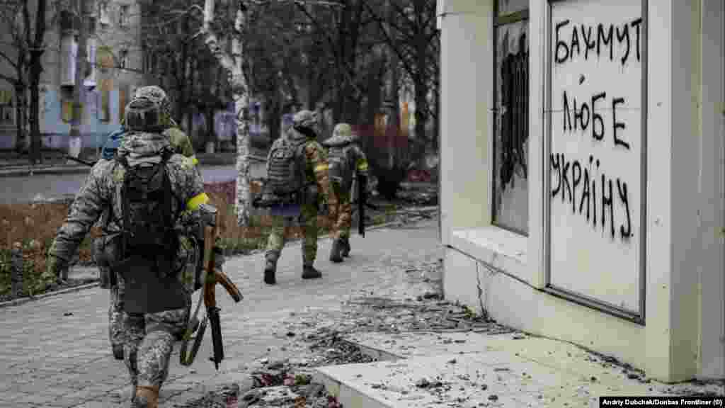 Militari ucraineni trec pe lângă un mesaj scris pe un zid: &bdquo;Bahmut iubește Ucraina&rdquo;, 18 decembrie.&nbsp; Rusia și Ucraina aruncă echipament și trupe în lupta pentru Bahmut, oraș în regiunea Donețk, estul Ucrainei, care are o importanță militară minoră, dar e revendicat ca simbol de ambele tabere. &nbsp;