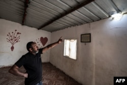 Mohamad Hassouna, în vârstă de 49 de ani, arată gaura provocată de un proiectil care a rănit-o pe fiica sa de șapte ani, Amina, în satul lor de beduini - nerecunoscut de autoritățile israeliene - în sudul deșertului Negev, pe 14 aprilie 2024.