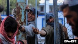 Disa afganë të mbledhur për të marrë ushqim falas në Kabul, Afganistan, 14 Prill 2022.