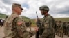KOSOVO -- A U,S, soldier (L) chats with a soldier of the Kosovo Security Force (KSF), following the 'Defender Europe 21' military exercise in the village of Deve, May 28, 2021