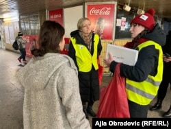 Vullnetaret Klaudia Kalita dhe Katarzyna Bialous ndihmojnë një grua nga Ukraina në stacionin e autobusëve Zahodnia në Varshavë, 8 prill 2022.