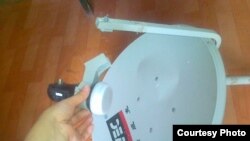 Жительница Жанаозена Айгул Болекбайкызы показывает разбитую спутниковую антенну. Жанаозен, 11 июня 2012 года. 