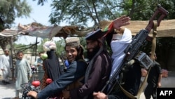 Taliban militants ride a motorbike as they took to the street to celebrate ceasefire in Jalalabad on June 16.