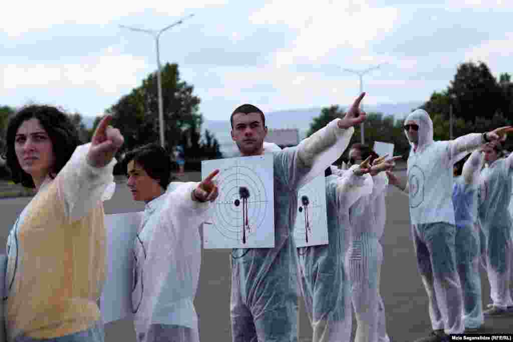 აქციის მონაწილეები თითს შინაგან საქმეთა სამინისტროსკენ იშვერენ.