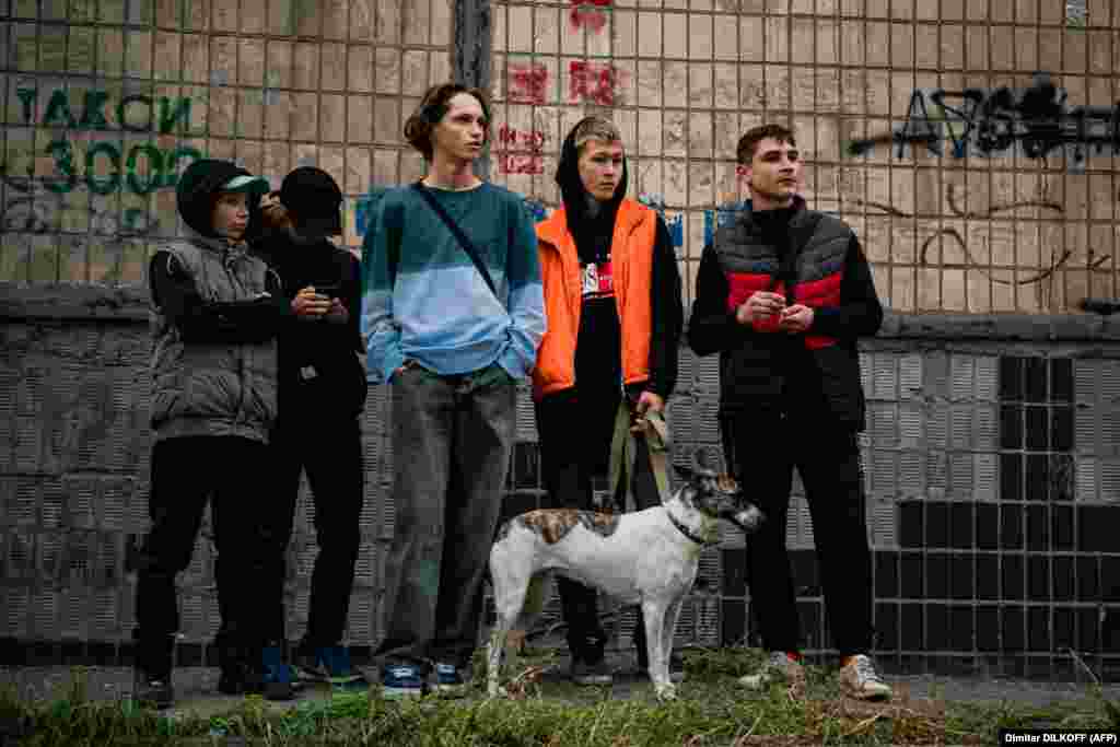 Підлітки дивляться на наслідки російських обстрілів їхнього міста. Щонайменше 16 українських міст зазнали ракетних та дронових атак. Багато з цих міст не обстрілювалися Росією з весни цього року