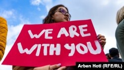 Fjola Zejnulahu, protestujući sa transparentom u rukama sa natpisom "Mi smo uz vas".