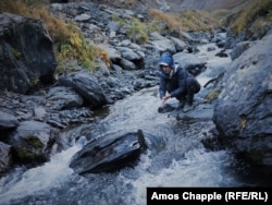 Ididze washes her hands in a mountain stream after making camp at the foot of the Abano Pass.
