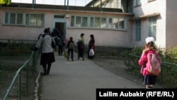 Мектеп алдында тұрған оқушылар. (Көрнекі сурет)
