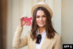 Кийра Найтли позира със своя Орден на Британската империя през 2018 г.