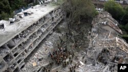 Punonjësit e shpëtimit dhe zjarrfikësit inspektojnë vendin e goditur drejtpërdrejt nga një raketë e lëshuar nga Irani në Tel Aviv, Izrael, të dielën, më 22 qershor 2025.