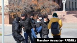 Полиция задерживает человека на месте анонсированного антиправительственного митинга в Алматы. Октябрь 2021 года
