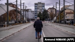 Një burrë duke ngarë biçikletën mbi urën e Ibrit, ndërmjet Mitrovicës së Jugut dhe Mitrovicës së Veriut. Fotografi nga arkivi.