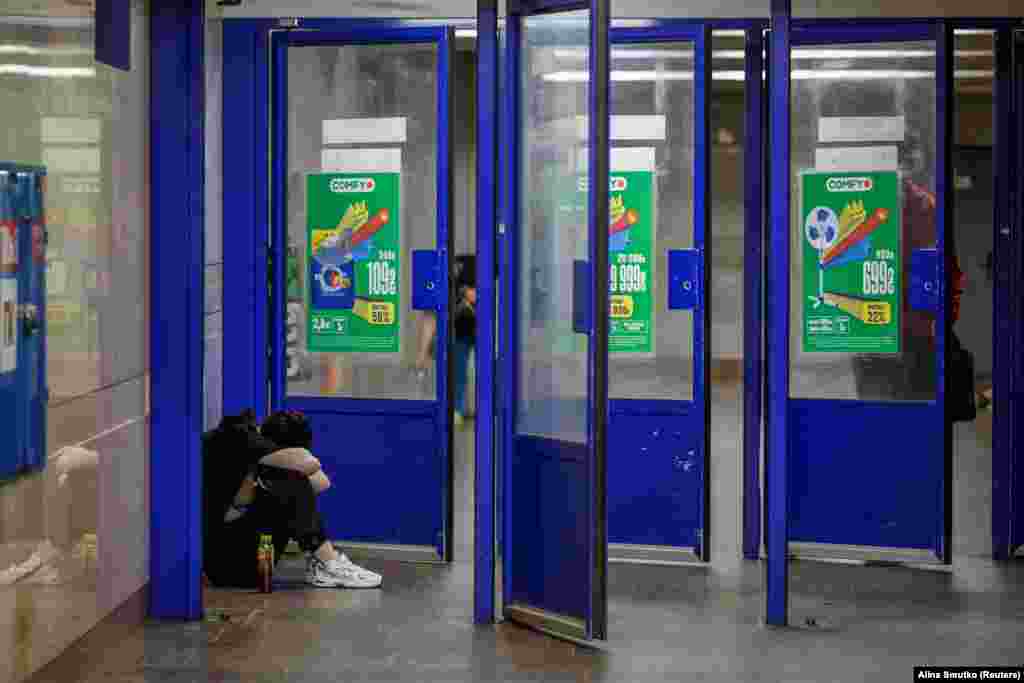 Një grua duke u strehuar pranë portave të një stacioni të metrosë në Kiev, më 9 korrik.