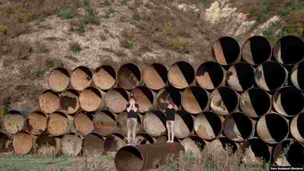 A kilencéves Mari Melua és húga, a hétéves Lola Melua vízvezetékeken állva játszik a Georgiától elszakított Dél-Oszétia régióban álló hegyek közelében, Khurvaleti faluban 2021. szeptember 27-én. &bdquo;A szomszédunk felment a hegyre, és egy orosz katona elfogta &ndash; mondta Mari. &ndash; Tudom, hogy nem szabad felmennem oda. Félek&rdquo;