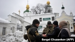 Служители на Службата за сигурност на Украйна проверяват документите на посетителите на манастира "Печерска лавра" в Киев на 22 ноември в рамките на продължилата седмици наред мащабна проверка по подозрения в проруска дейност.