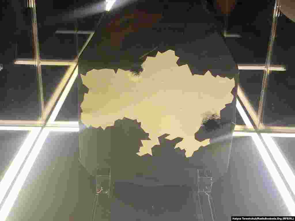 O placă Kevlar deteriorată în luptă cu o hartă a Ucrainei. Organizatorii expoziției spun că intenționează să strângă bani din vânzarea acestor lucrări de artă pentru a cumpăra mai multe armuri pentru trupele ucrainene.