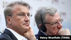 Ресейлік Сбербанк басқармасының басшысы Герман Греф (сол жақта).