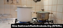 Valentyna heats two pots of water as the steam they produce helps heat up her kitchen a little.