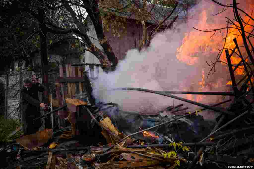 Місцевий житель намагається загасити пожежу після обстрілу в місті Бахмут. 23 жовтня 