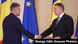 Premierul Ciolacu la jurământul de învestitură de la Palatul Cotroceni, din vara lui 2023, dând mâna cu președintele Klaus Iohannis, ambii în fruntea țării în momentul fără precedent al anulării prezidențiale din decembrie.