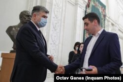 Marcel Ciolacu în timpul ședinței de dezbatere și de vot a moțiunii înaintate de PSD împotriva guvernului Cîțu, în București, octombrie 2021. Liderul PSD dă mâna cu liderul AUR, George Simion.