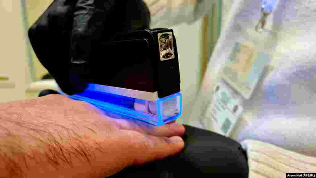 Komisionerët kontrollojnë duart e një votuesi në Prishtinë.&nbsp;