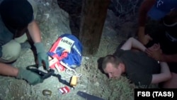 Гражданин Украины Геннадий Лимешко во время задержания сотрудниками органов федеральной службы безопасности при попытке повредить линию электропередач в районе трассы Судак – Новый Свет. Снимок с видео/ЦОС ФСБ России/ТАСС. Крым, 15 августа 2017 года