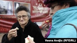 Ljudi jedu hleb na ulici u Beogradu, tokom lomljenja božićnog kolača, ilustrativna fotografija