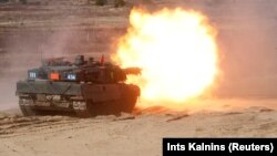 Një tank i llojit Leopard 2, i ushtrisë gjermane, duke shtënë gjatë manovrave të NATO-s, në Letoni, më 2021.