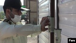 An official seals the door of a restaurant in the southern city of Mahshahr after a woman sang at its opening.
