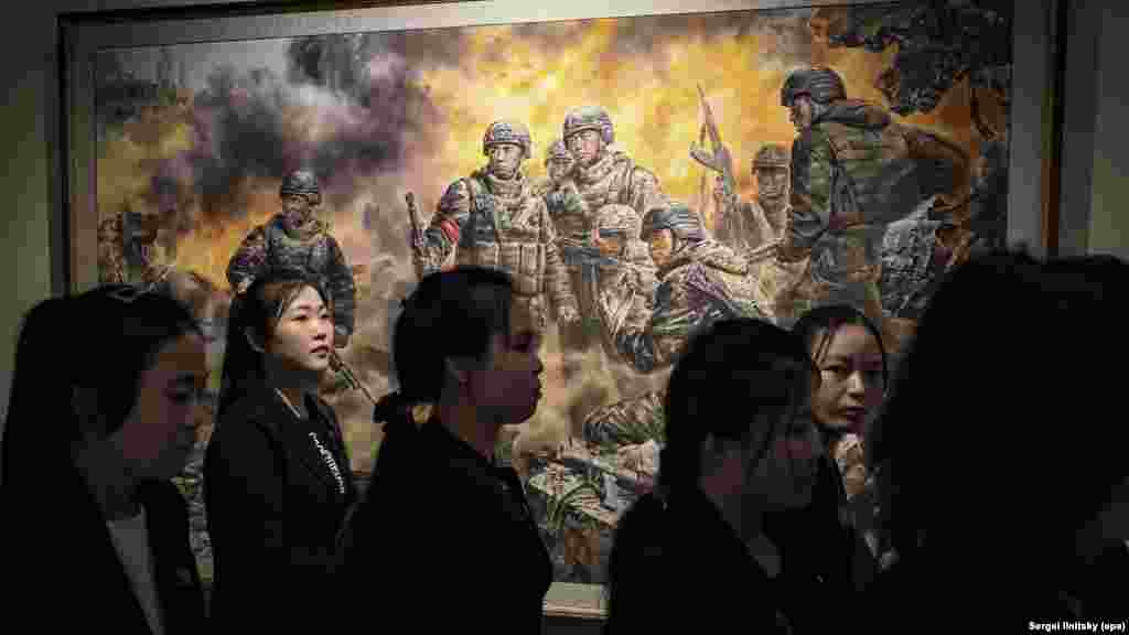 Észak-koreai turisták a Hősi harcosok a haza méltóságáért és becsületéért című festmény előtt
