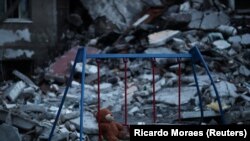 Medvjedić visi na ljuljaški pored oštećene zgrade u Harkivu, Ukrajina, 17. maja 2022.