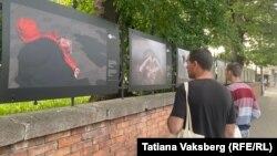 Димитър и двете му деца разглеждат снимките на Ройтерс от войната в Украйна. София, бул. "Васил Левски", 24 май 2022 г.