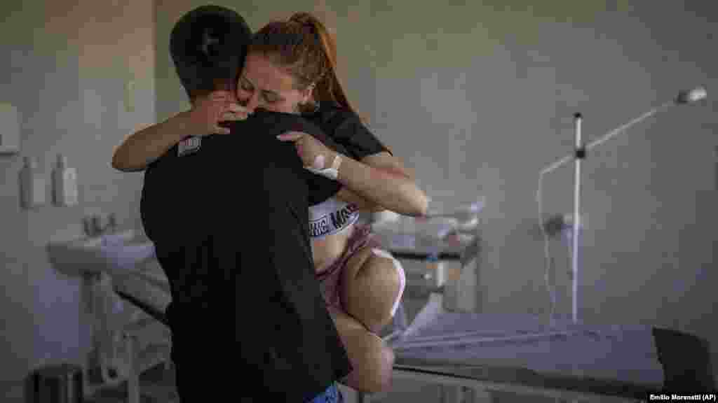 Oksanu Balandinu, 23, nosi njen suprug Viktor u bolnici u Lvivu 13. maja 2022. Oksana je izgubila obe noge i četiri prsta na levoj ruci kada je eksplodirala granata u blizini njene kuće. &quot;Došlo je do eksplozije. Noge su mi se odmah nakon toga osećale kao da padaju u prazninu. Pokušavala sam da pogledam okolo i videla da više nema nogu - samo kosti, meso i krv&quot;, priseća se ona. &nbsp;