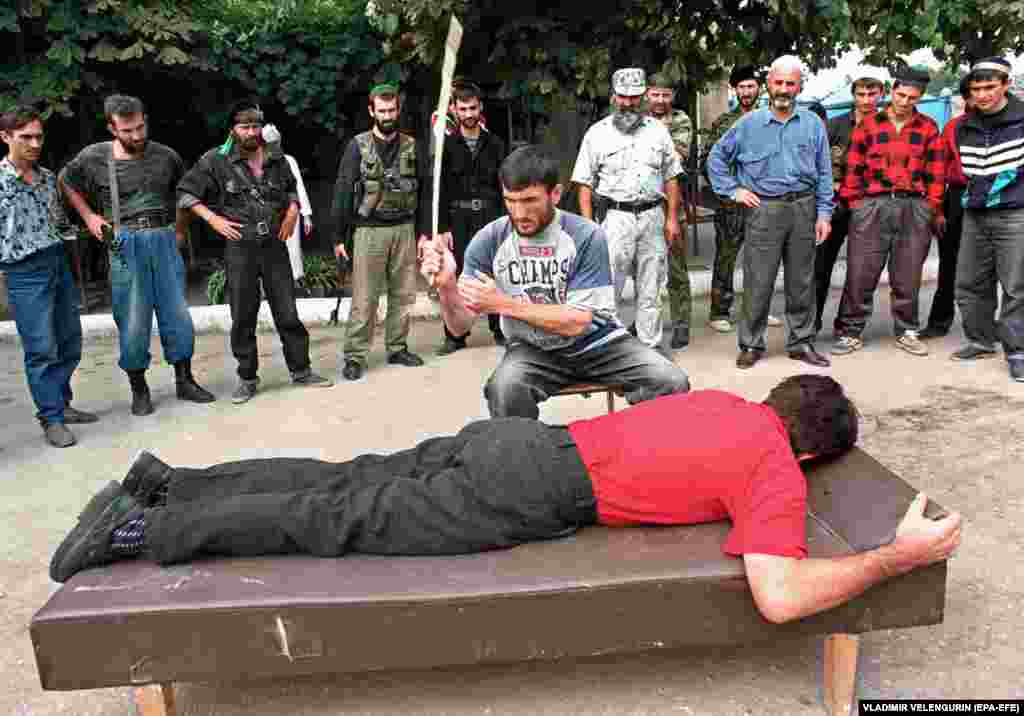 A man being flogged in Grozny in 1996. The devastation of the war and the relative isolation that followed made Chechnya a breeding ground for extremism, and street violence became a major problem. In 1997, the region adopted Shari&#39;a law and began to carry out public executions.