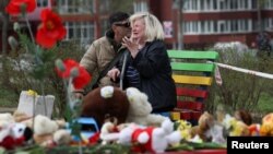 Ljudi plaču na mjestu smrtonosnog ruskog raketnog udara na stambeno naselje u Krivom Rihu, u kojem je 5. aprila poginulo 20 ljudi, od kojih devetoro djece